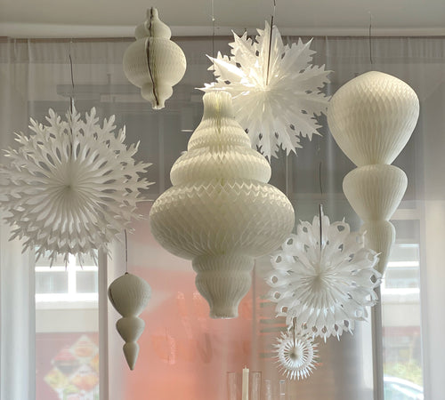 christmas decorations in window at bello. All white paper lanterns in snowflake and drop shapes