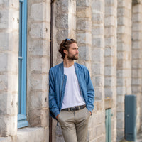 Braided belt in dark brown and white with brown leather detail on model in blue jacket leaning against wall