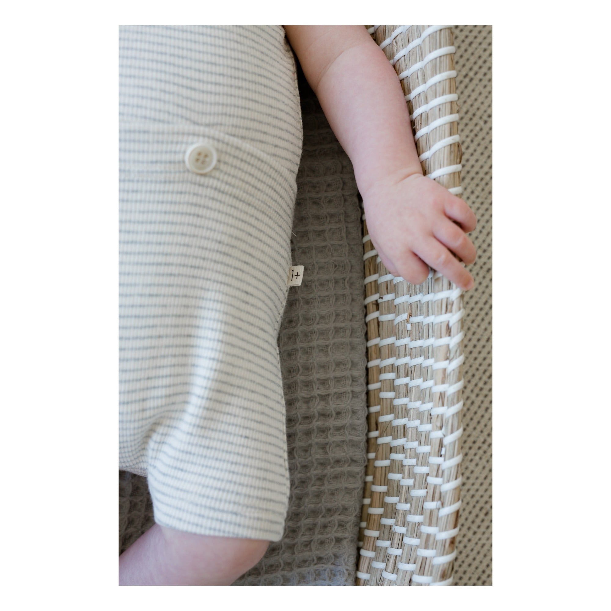 White organic cotton jumpsuit short sleved up close of fabric, faint grey stripes