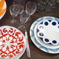 Blue and white, and red and white kashgar dinner plates on table, with other kashgar tableware.