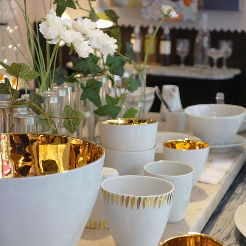 Gold and white bowls in table setting designer tableware 