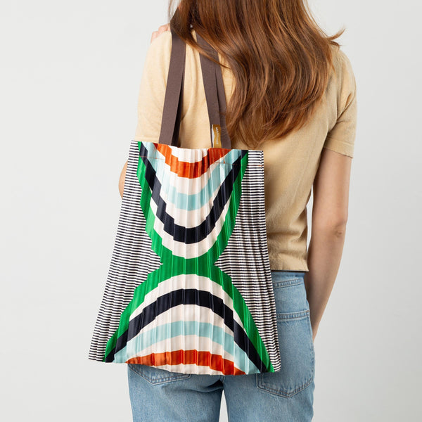 Person wearing a colorful striped bag on a plain background