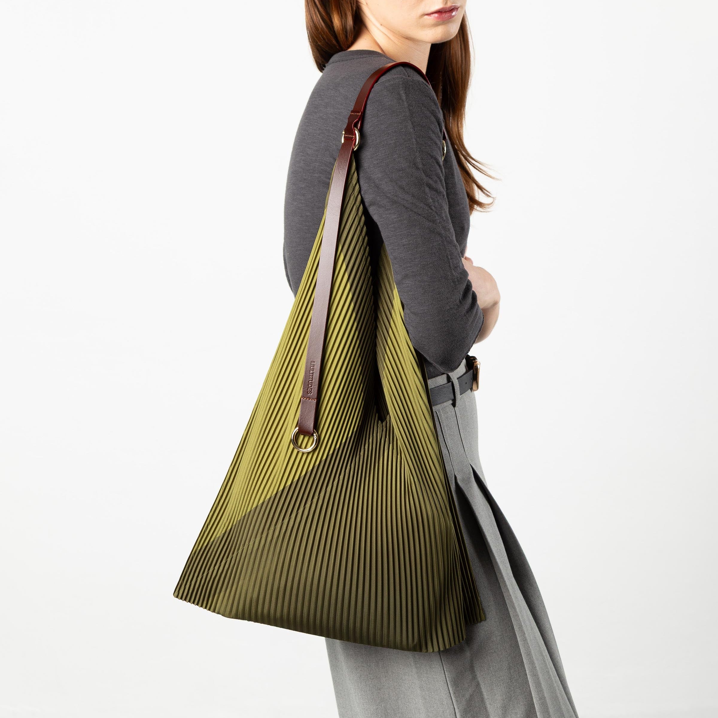 Woman carrying a green pleated bag on a white background