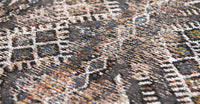 Closeup of rug with Morrocan nomad pattern in grey and blue muted tones.