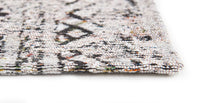 Edge detail of rug with Morrocan nomad pattern in white tones with grey detail.