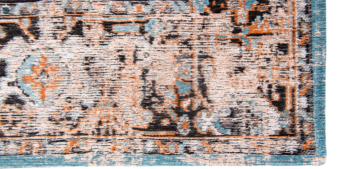 Closeup of blue edge of rug with central medallion, rosette shaped with a stair patterned parameter.
