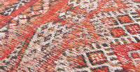 Closeup detail of rug with Morrocan nomad pattern in red tones.