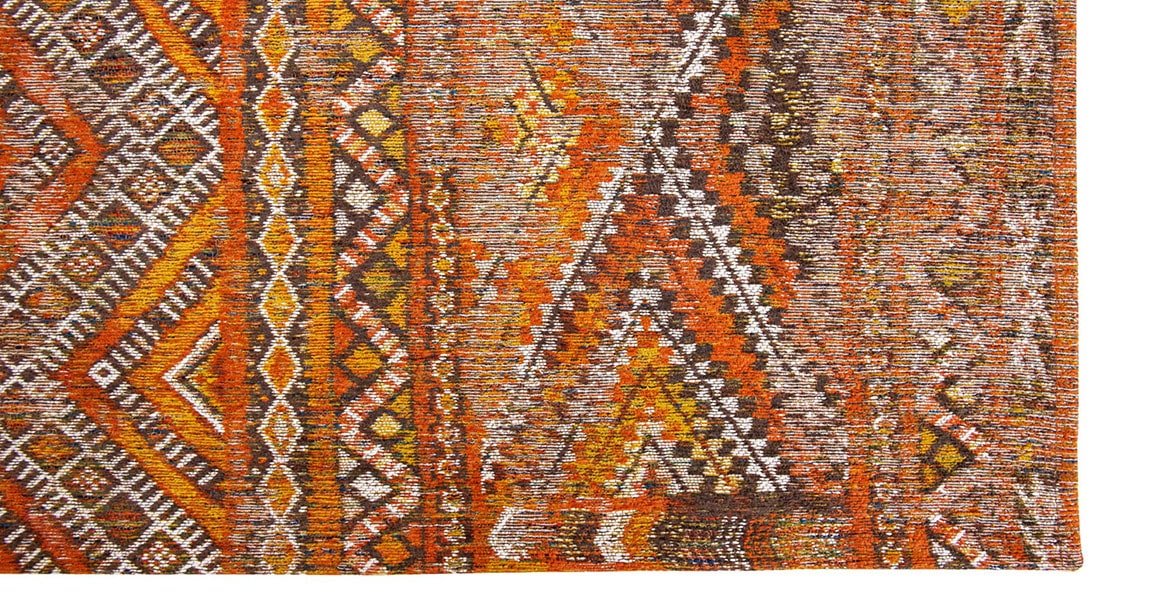 Corner view of rug with Morrocan nomad pattern in orange tones.