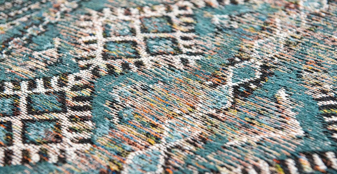 Closeup detail of rug with Morrocan nomad pattern in blue tones.