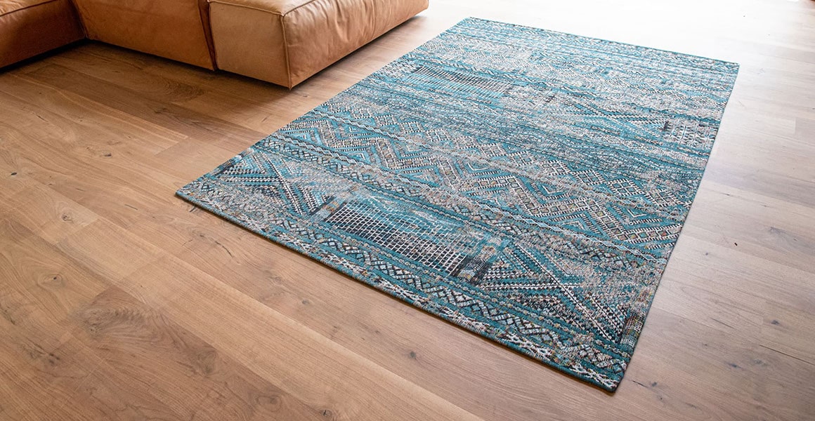 rug with Morrocan nomad pattern in blue tones on wooden floor full view