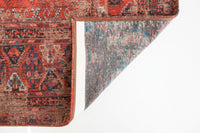 Underside view of rich red tone distressed rug with antique pattern detail