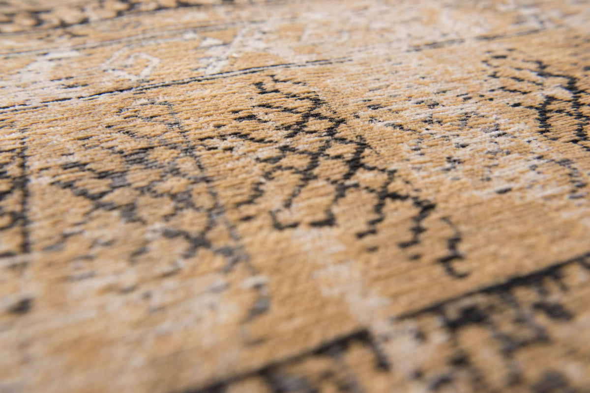 Closeup of cris cross detail on warm beige distressed rug