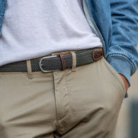 Braided belt in dark brown and white with brown leather detail on model in beige pants